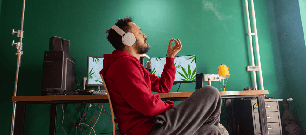 Mann raucht CBD Joint am Schreibtisch zur Entspannung